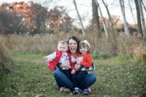Mom in field, hugging two young girls