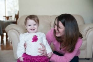 Mom watching toddler stand and smile