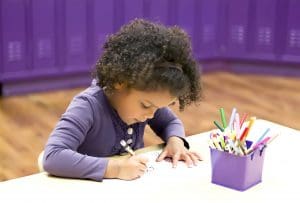 Young child working on coloring at a table - Executive Function Skills Kinderberry Hill