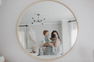 Mother holding her one year old on top of her pregnant belly. Embracing my fears over three under three.
