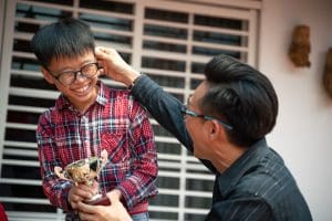 an asian chinese father complimenting his son