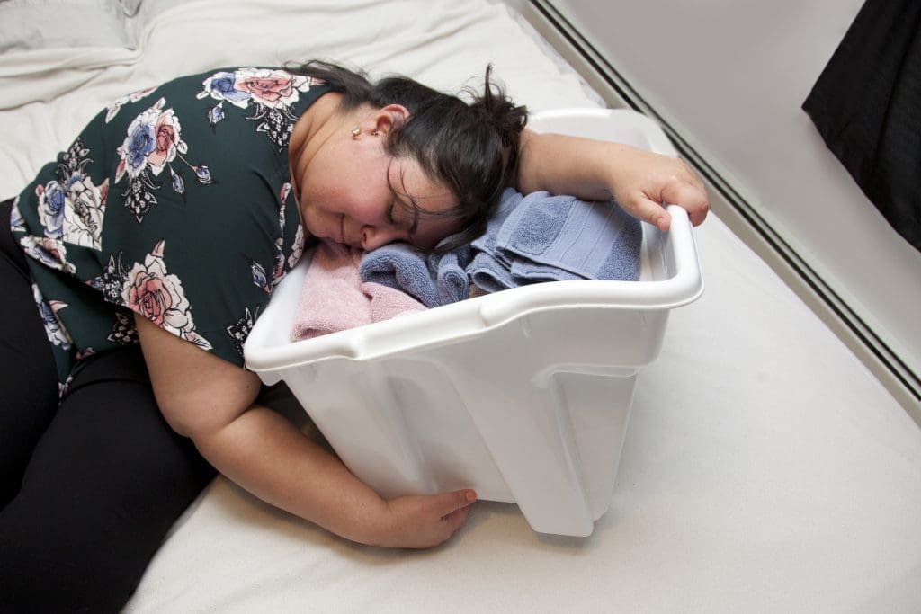Tired mom asleep in her laundry basket