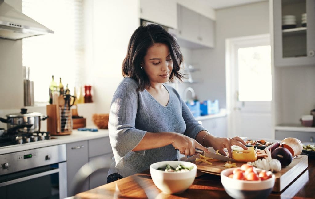 Shot of an attractive young woman cooking at home. Support your immune system