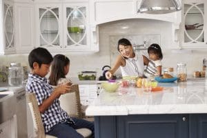juggle it all: Busy Mother Organizing Children At Breakfast In Kitchen