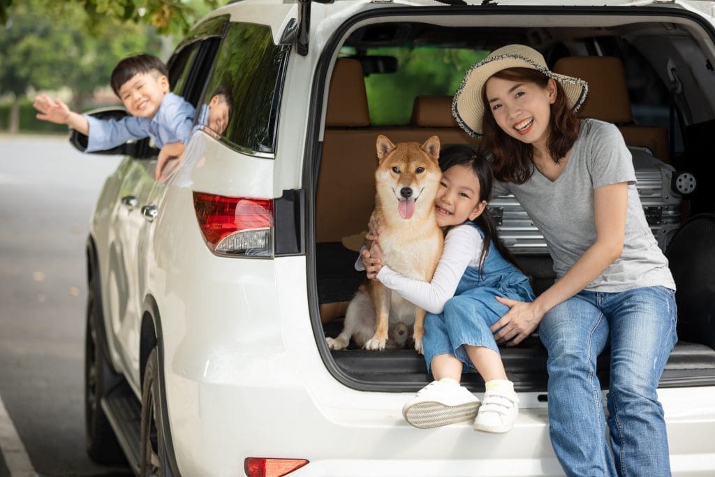 Asian mom with her son and daughter and dog. Road trip survival guide
