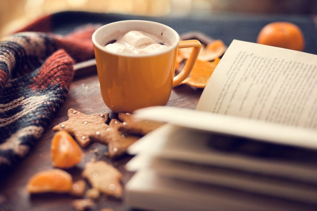 Cup of hot cocoa and an open book. Books to Re-Read this fall