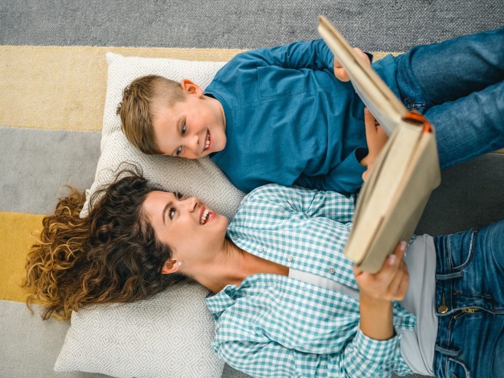3 steps to chapter books Little boy and mother enjoying book together.