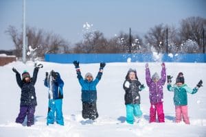 Kindergarten children having fun in the snow