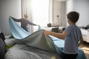 Little boys are making bed in their room. Helping Children Cultivate Habits