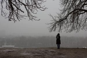 woman standing alone in the park on gloomy day. 5 winter blues tips