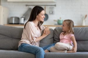 Happy young adult mother and cute child enjoy talking relaxing - choose to step in