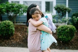 A Korean woman holds her daughter tightly in an embrace,