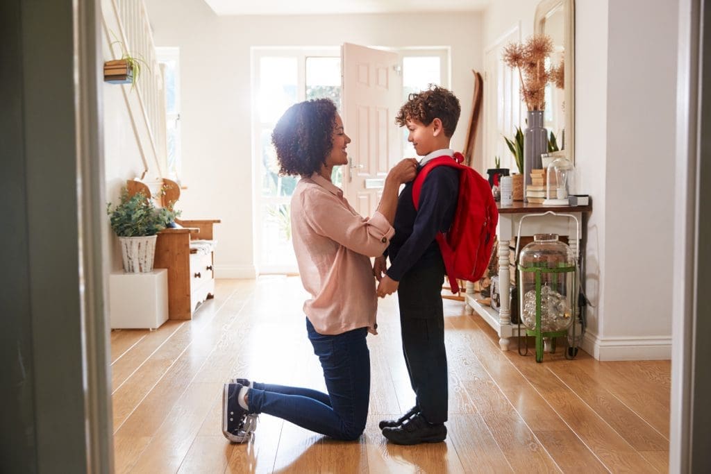 Single Mother At Home Getting Son Wearing Uniform Ready For First Day Of School - child's self-worth