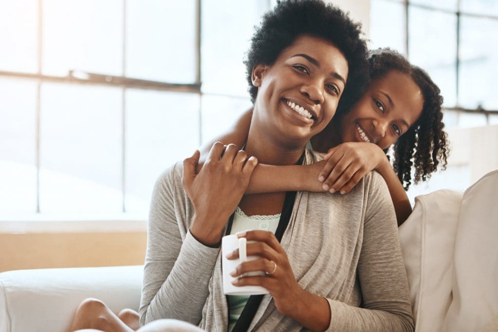 Shot of a mother and daughter at home - mom holding coffee - ways to upgrade your coffee