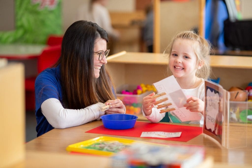 tending to the whole child 2022 - daycare worker and child working at a table