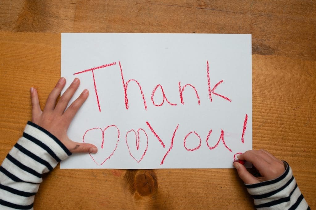 Child writes thank you on paper - different ways to say thank you