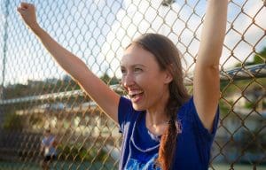a excited proud mother cheering on her kid at a game outside. Be a winning sports parent