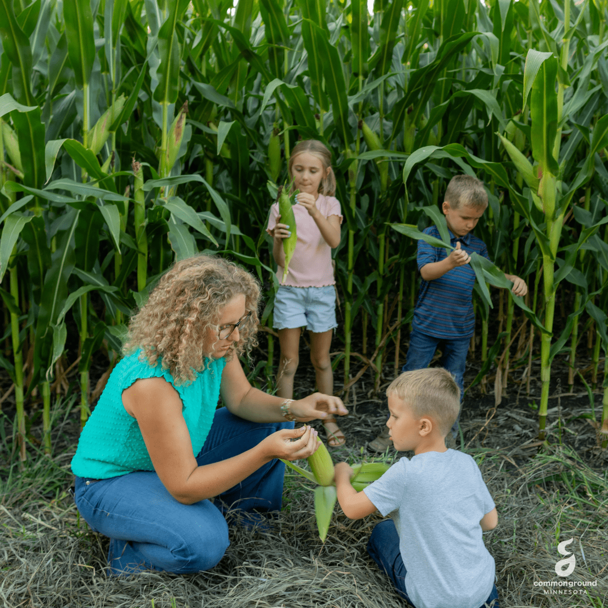 CommonGround Minnesota woman crouching to show a child an ear of corn