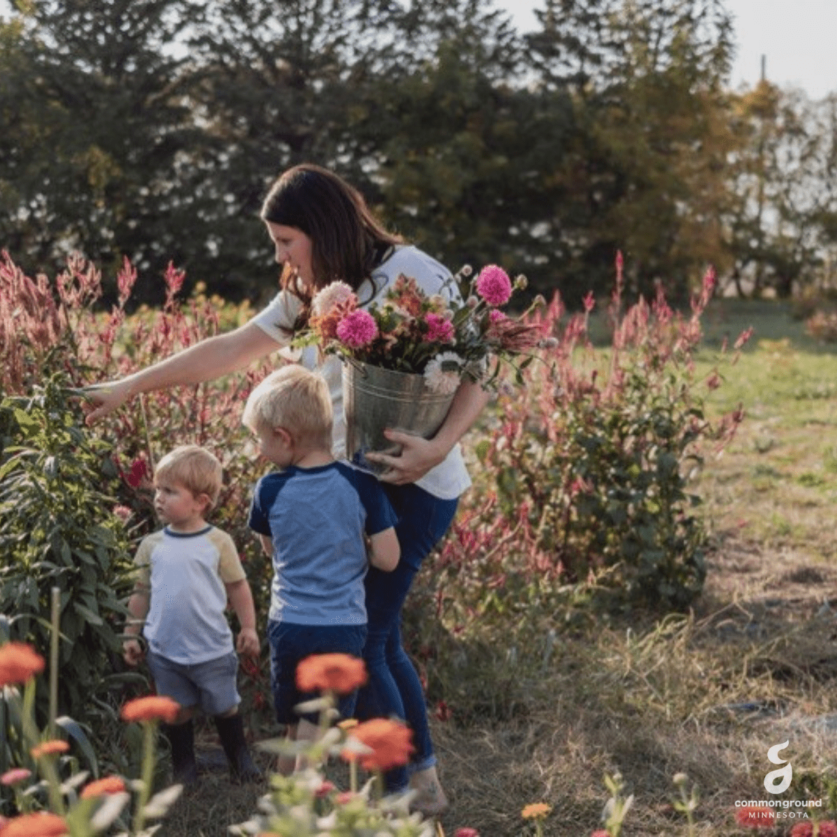CommonGround Minnesota woman with two children picking flowers in a field
